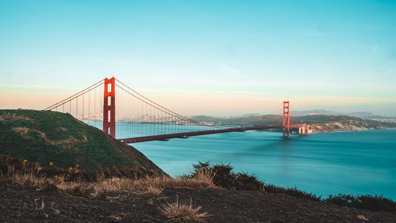 vision Stunning view of the Golden Gate Bridge during sunset, overlooking the ocean and shoreline.