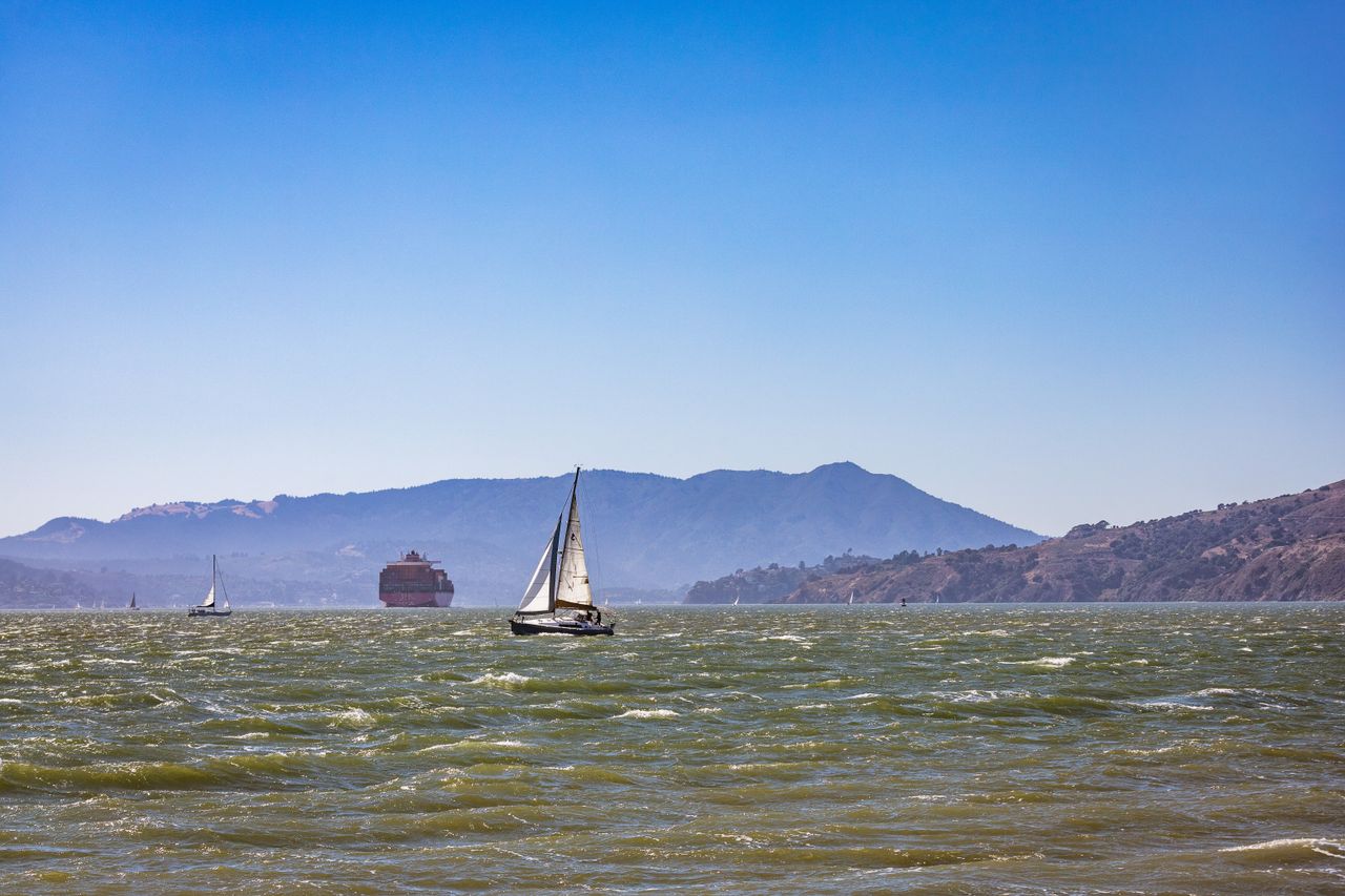 gallery-02 Sailboats navigate San Francisco Bay's azure waters with scenic hills in the backdrop.