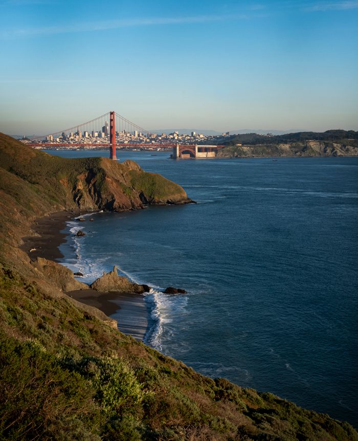services-01 A stunning view of San Francisco's iconic Golden Gate Bridge with rolling coastline under bright skies.